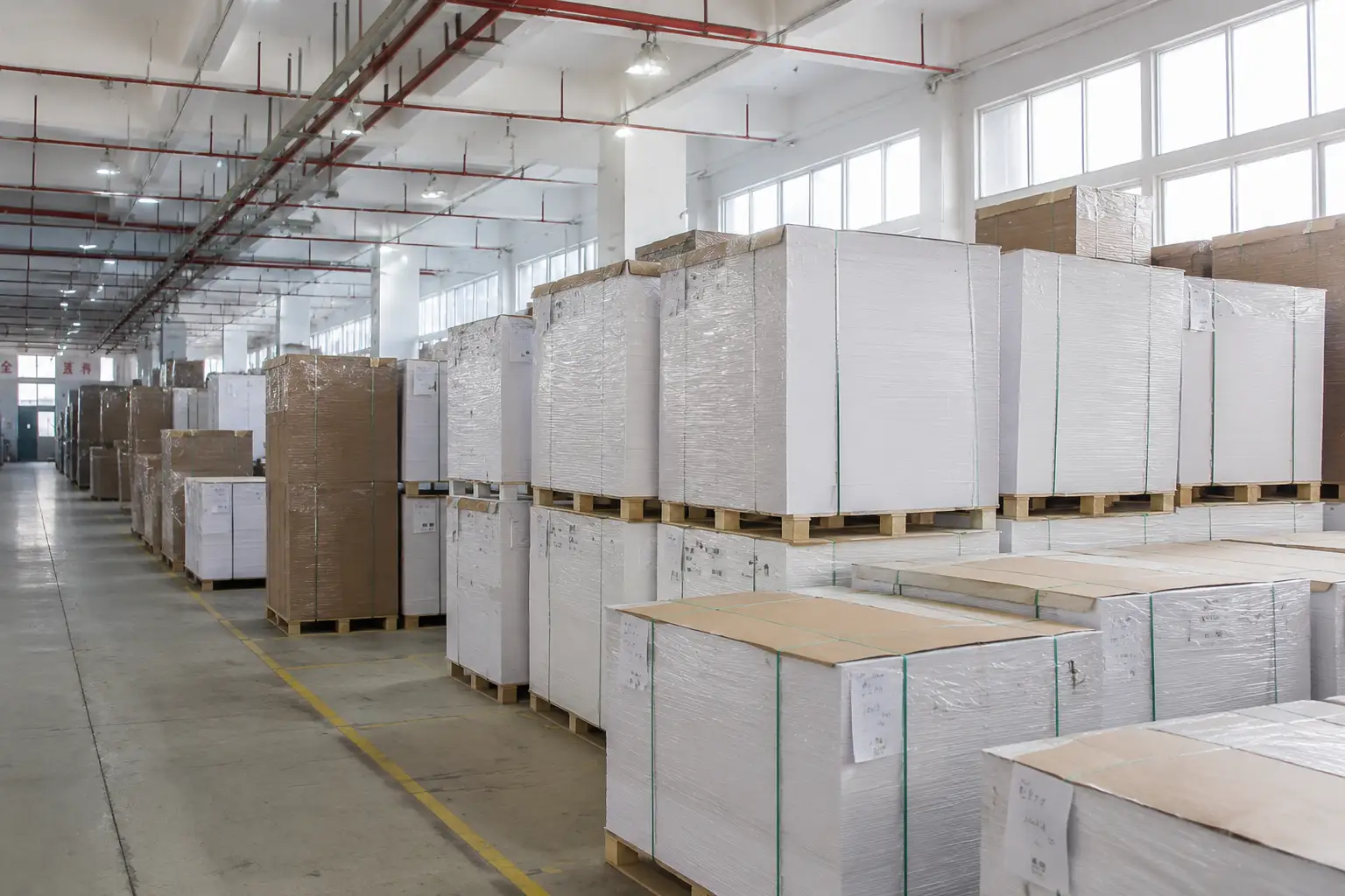 Stacks of paper materials stored in a packaging factory warehouse before production