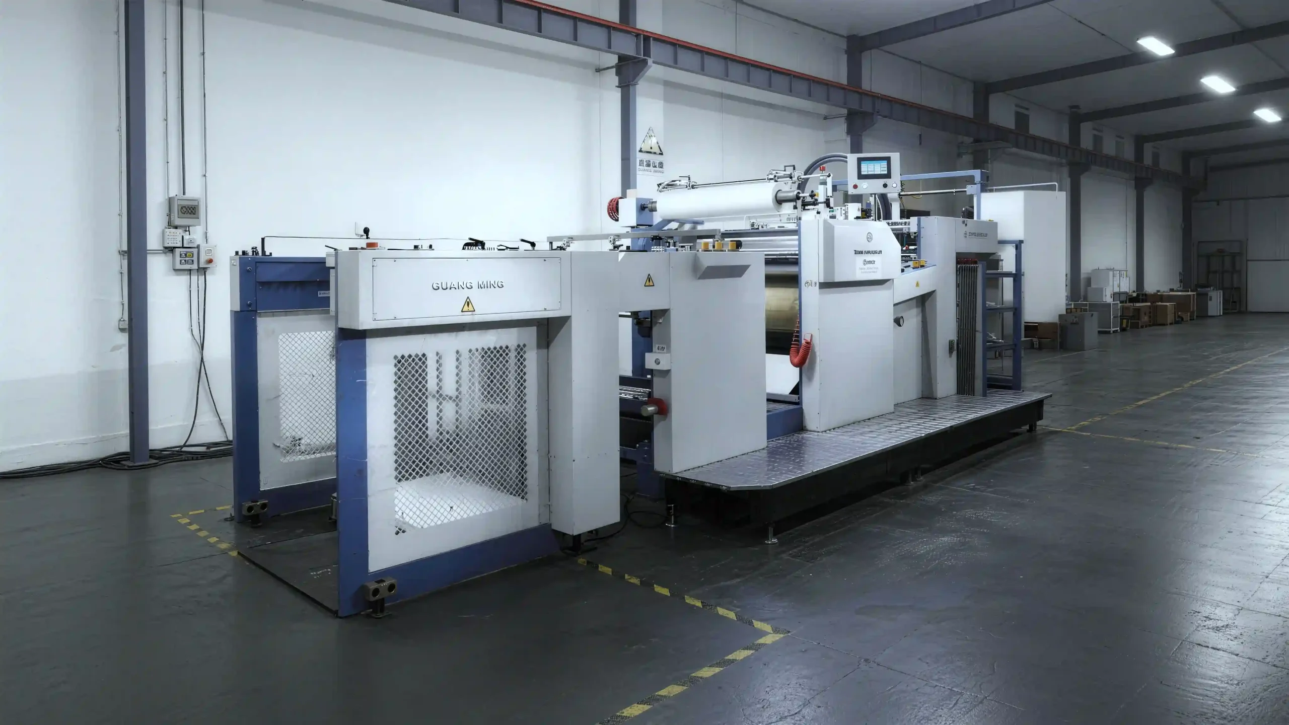 Automatic film laminating machine for applying protective and decorative film to printed packaging paper